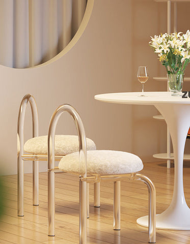 Modern metallic chairs with curved clear plastic frames and plush cashmere seat pads for dressing table use