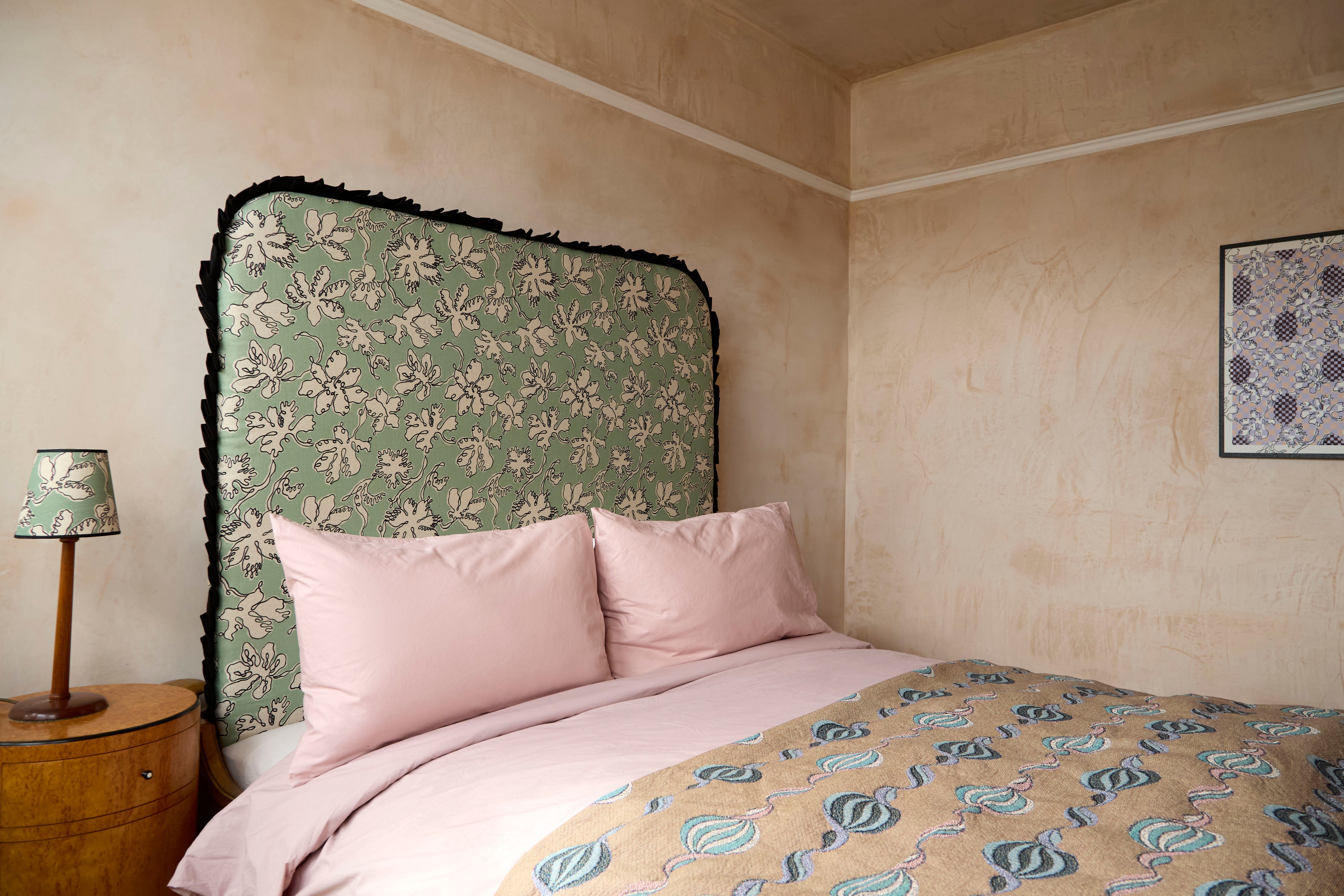 Curved frill headboard in sage green natural linen with off-white floral pattern and black fringe by micaela sharp