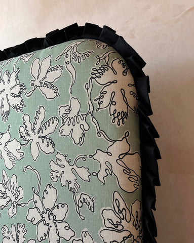 A seafoam curved frill headboard with natural linen light green floral cushion by micaela sharp collaboration