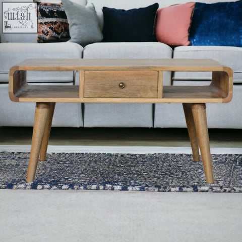 Curved oak light wood coffee table with single drawer and tapered legs made from solid mango wood