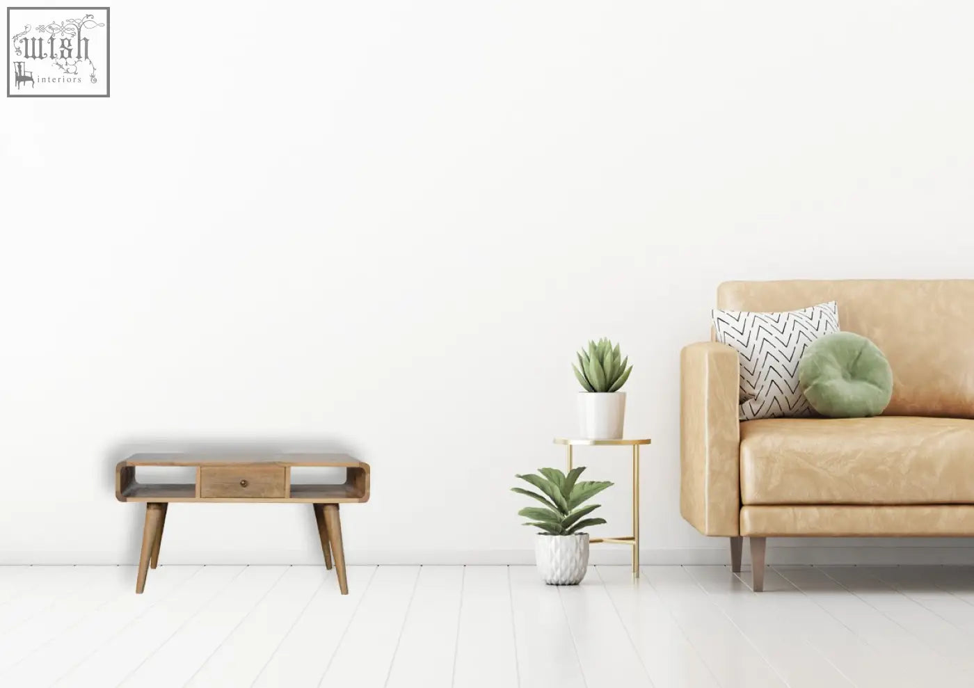 Tan leather sofa with geometric pillow and round green cushion next to a curved oak solid mango wood coffee table