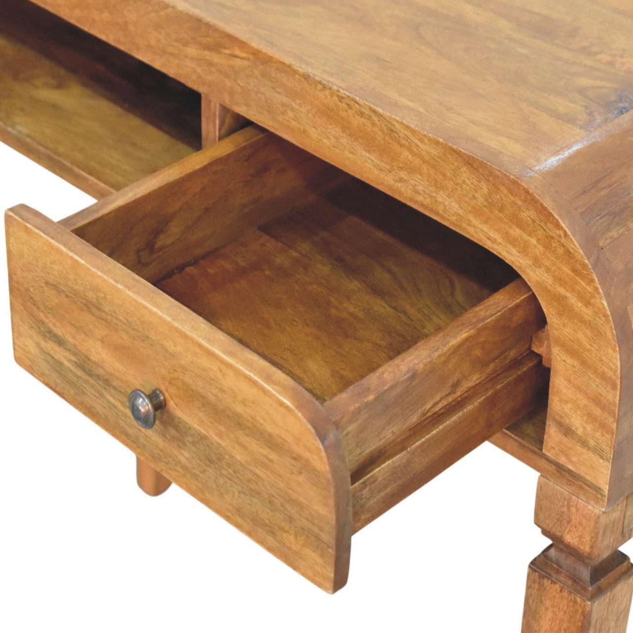 A warm-toned wooden curved open shelf writing desk with a curved drawer front and metallic knob