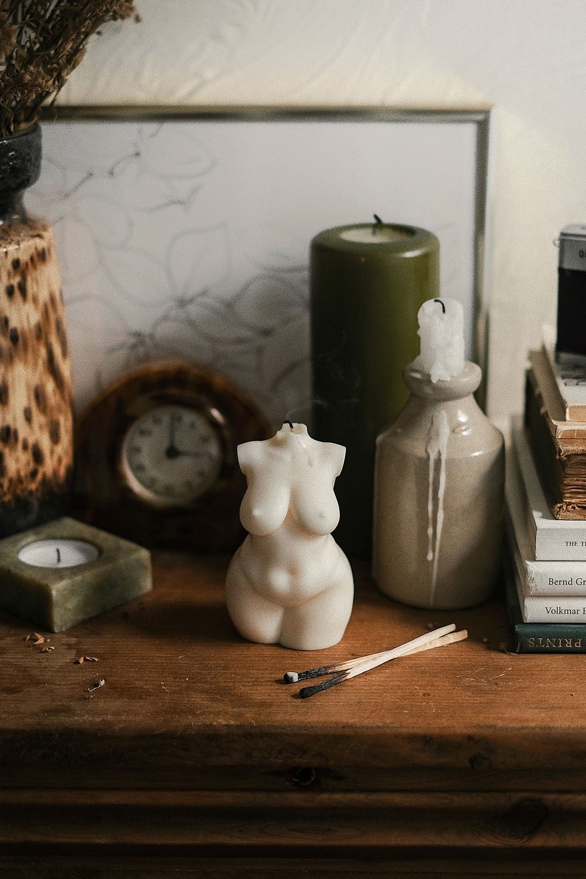 Cream-colored curvy body candle shaped like a sculpted female torso with smooth 1px solid edges