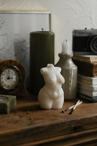 Cream-colored sculpted body candle shaped like a curvy female torso with smooth 1px solid edges for decoration