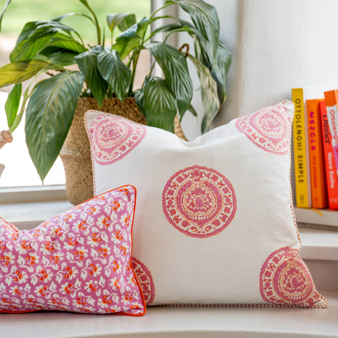 White cushion cover with burnt spice pink and peach mandala patterns and floral design on a smaller accent pillow
