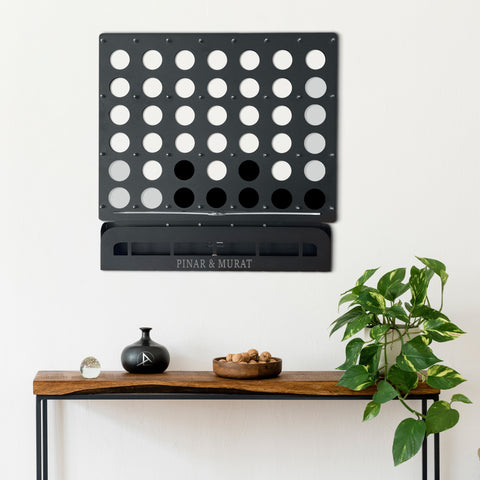 Customized connect four wall game in black metal with circular holes and a sleek modern design for connect four wall play