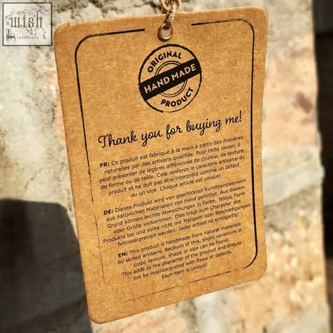 Brown kraft paper tag on solid mango wood console table with original handmade stamp and multilingual thank you text