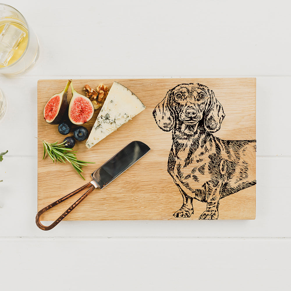 Light-colored oak serving board with detailed black engraved dachshund illustration perfect for cheese and snacks