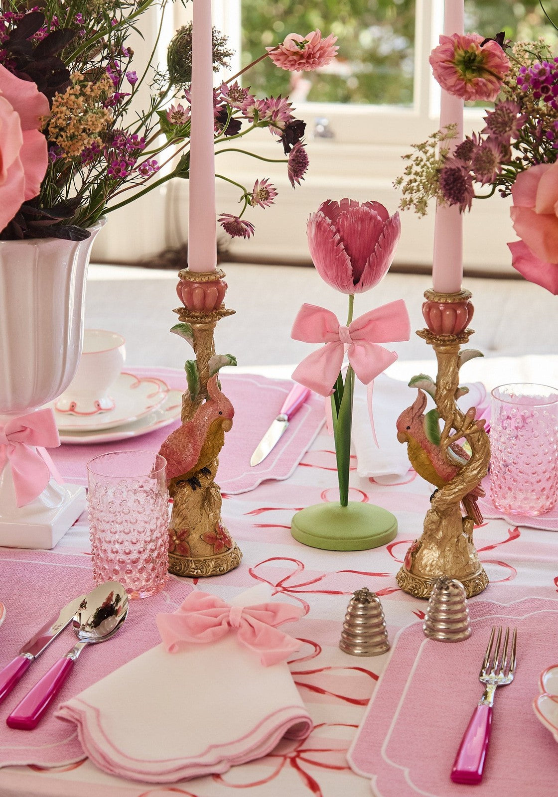 A delicate pink petal tulip candleholder with a matching bow on a green tole base for dahlia decor