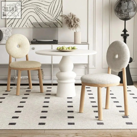 Cream-colored daiki chair with round donut-shaped backs and light wood legs upholstered in faux lamb wool