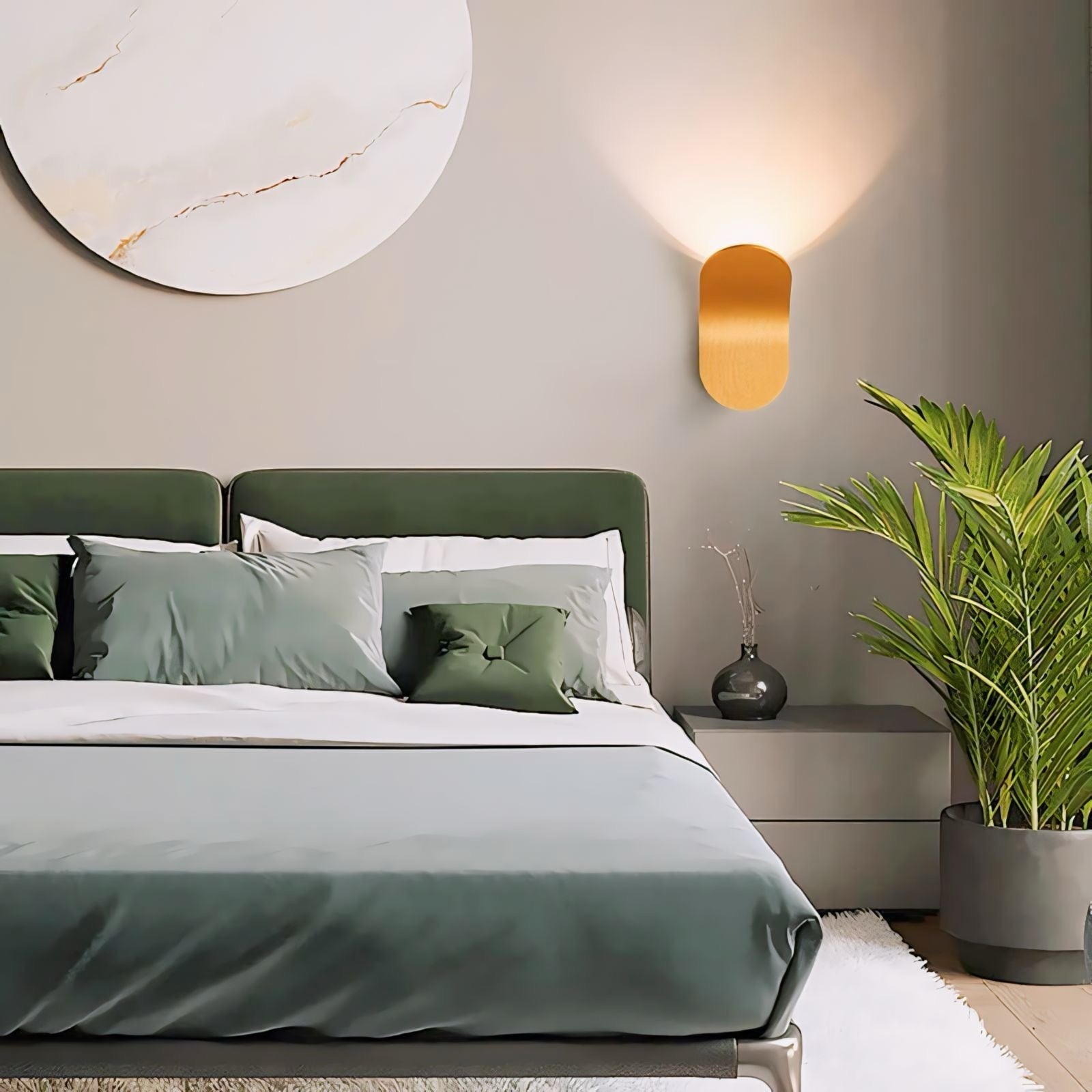 Gold-toned oval daisuke light wall lights with smooth reflective surface casting warm ambient light