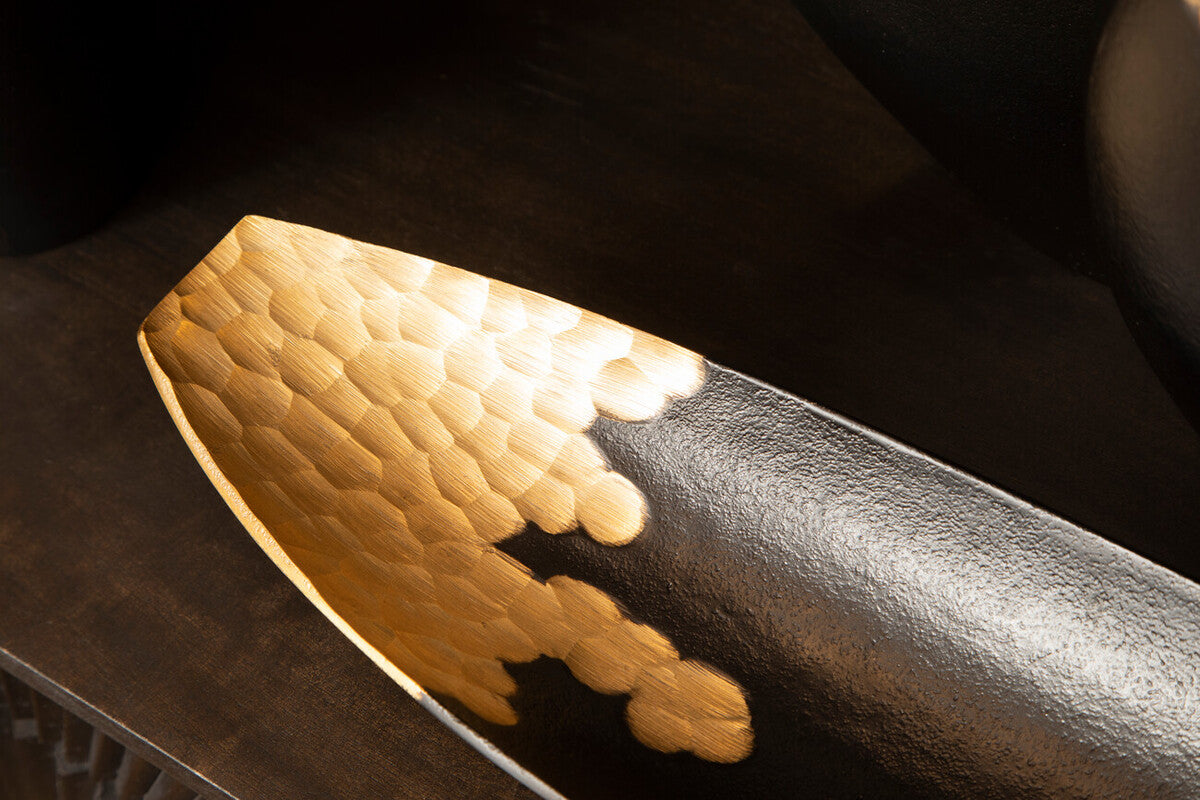 A sleek elongated gold boat dish with half polished hammered gold and half matte black finish called daito black and gold boat dish
