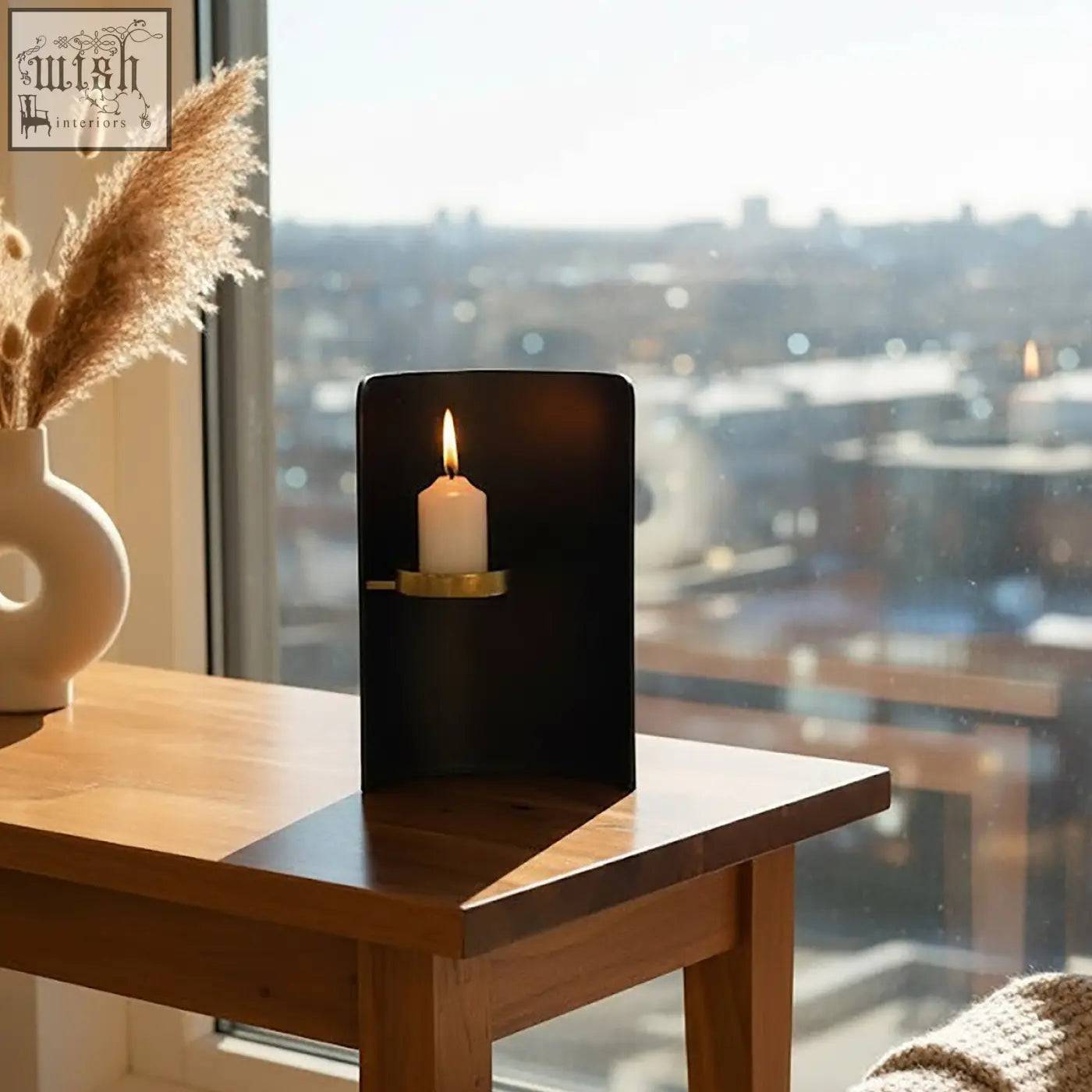 Daito black and gold finish candle holder with a minimalist design cradling a white pillar candle