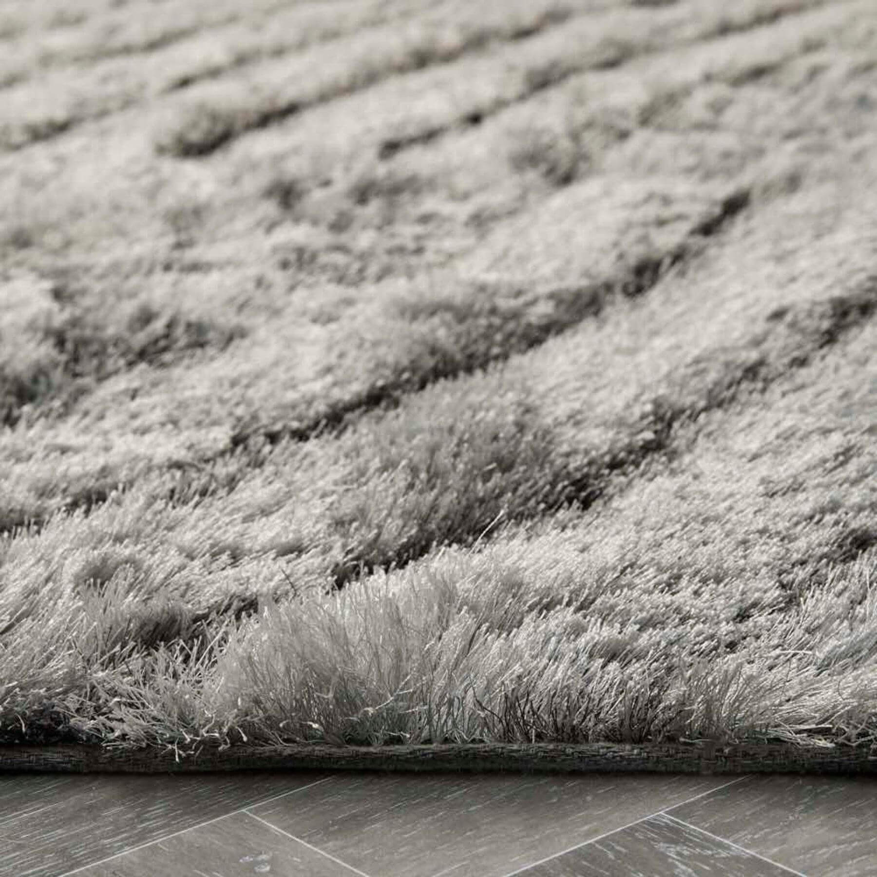 A dallas silver grey shaggy rug with a plush, textured wave-like pattern and dense soft pile in silver grey color