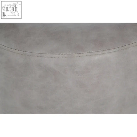 Light gray suede-like ash grey faux leather pouffe with subtle texture and fine stitching along curved edge