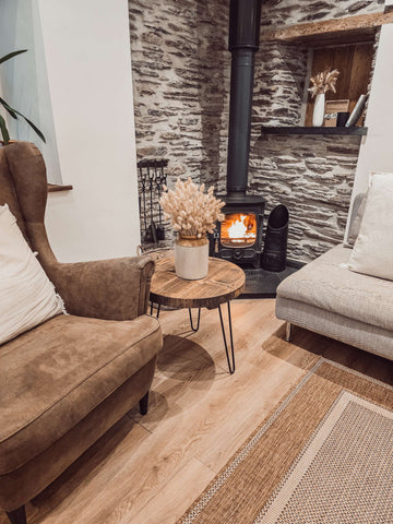 White ceramic vase with dried pampas grass on dalva walnut round coffee table rustic wooden surface seen