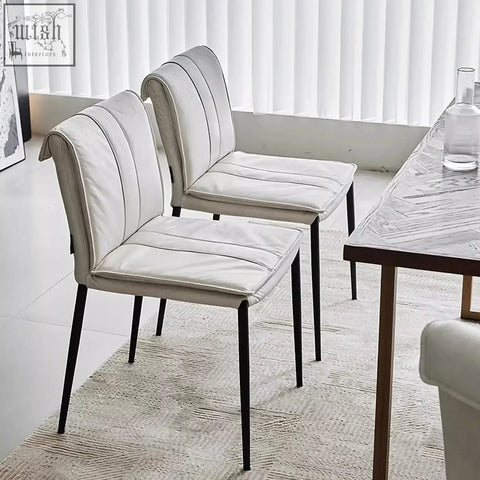 Modern white d’amato dining chair with leather upholstery black metal legs and vertical stitching details
