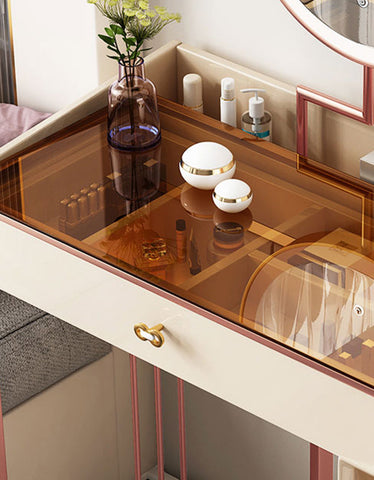 Modern damion dressing table with translucent amber glass top cream body and rose gold metal frame accents