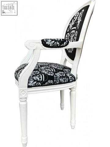 White wooden bowler arm chair by dan gold with black skull and floral upholstered seat and back