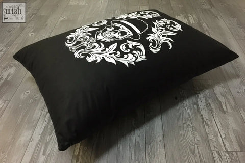 Black rectangular floor pillow with bold white skull and floral design from dan gold bowler cushion collection
