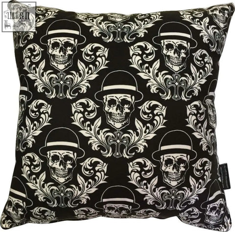 Black dan gold bowler cushion with white skulls in bowler hats and ornate floral cross patterns on soft fabric