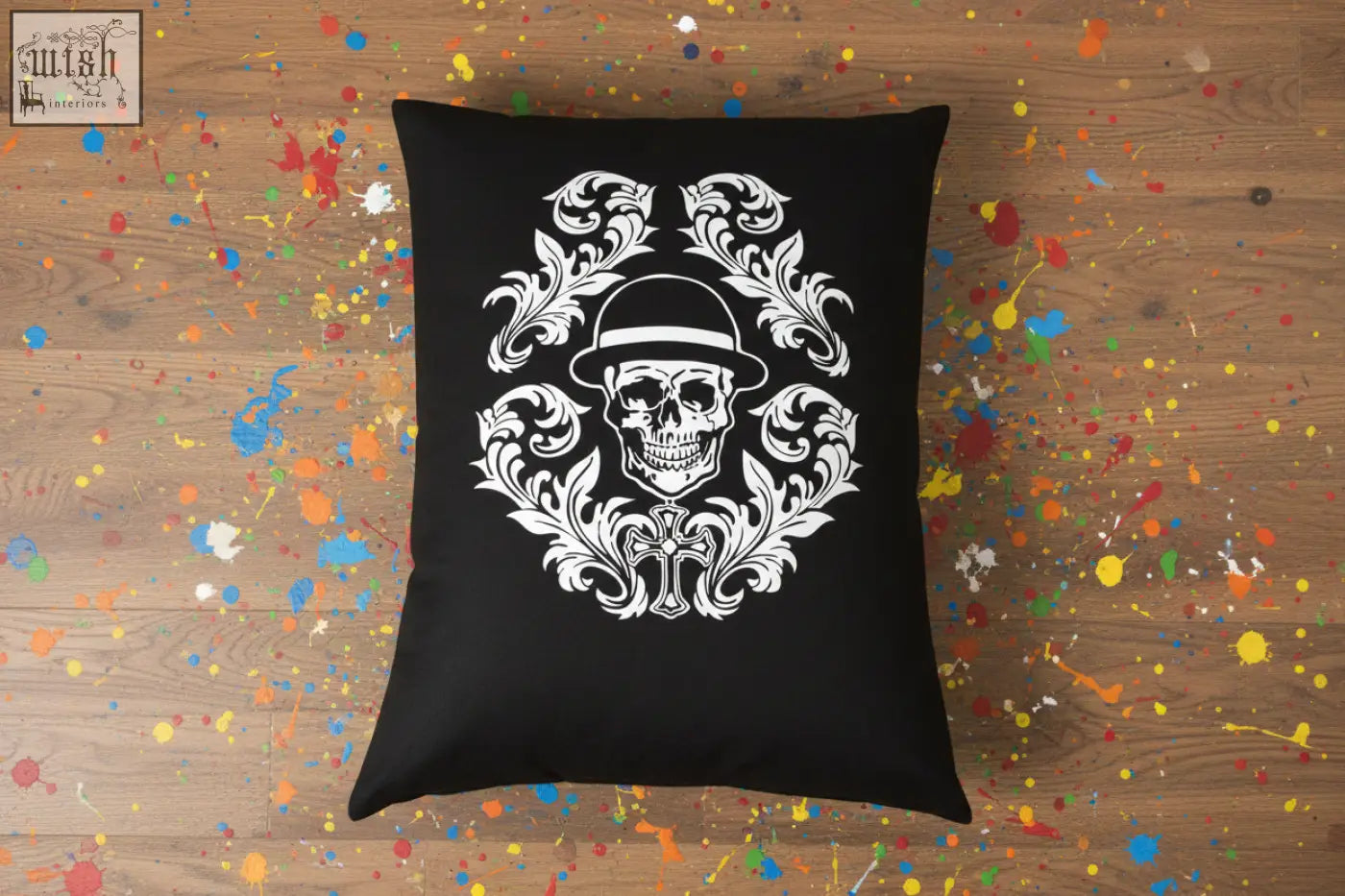 Black throw pillow with a white ornate skull design wearing a hat and floral patterns from dan gold bowler cushion