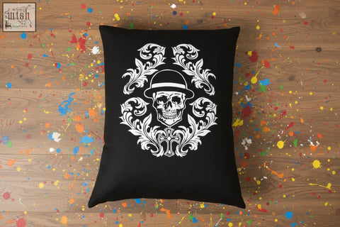 Black throw pillow with a white ornate skull design wearing a hat and floral patterns from dan gold bowler cushion