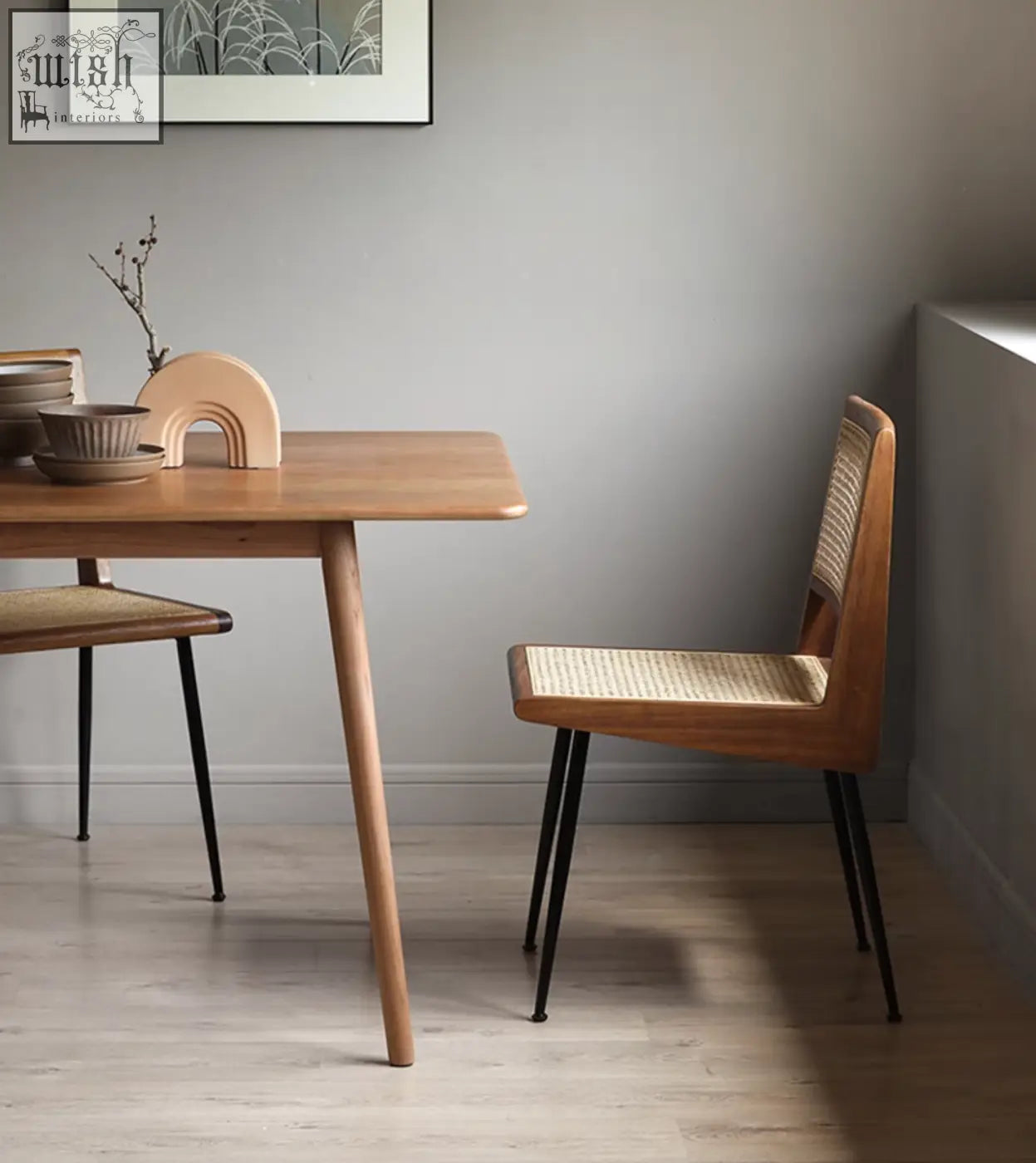 Dana rattan dining chair with minimalist wooden frame, woven cane seat and back, and black metal legs perfect for dining rooms
