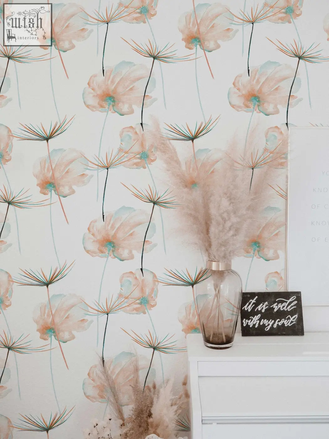 A translucent amber glass vase with pampas grass complements teal floral peel and stick removable wallpaper for living space