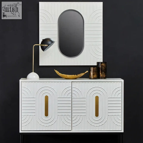 Off-white wall mirror with a white cabinet featuring gold-toned vertical handles and a geometric embossed pattern