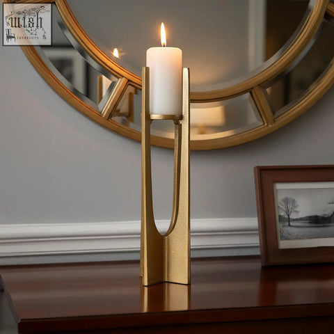 Dante large gold finish candle holder with sleek gold finish holding a white pillar candle in modern style
