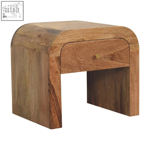 Curved darcy bedside table made of solid mango wood with a single drawer and brass knob in natural finish