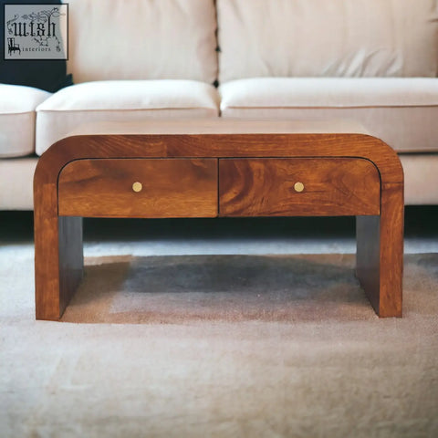 A sleek arched wooden darcy chestnut coffee table with two drawers and brass knobs in chestnut finish