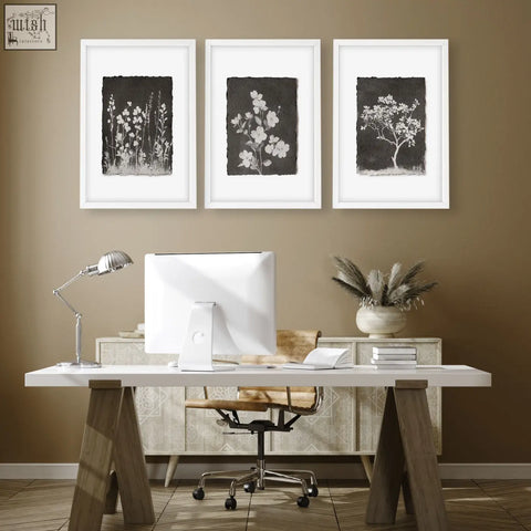 White framed botanical wall art prints on dark brown wall featuring wildflowers and blossom tree designs set of 3