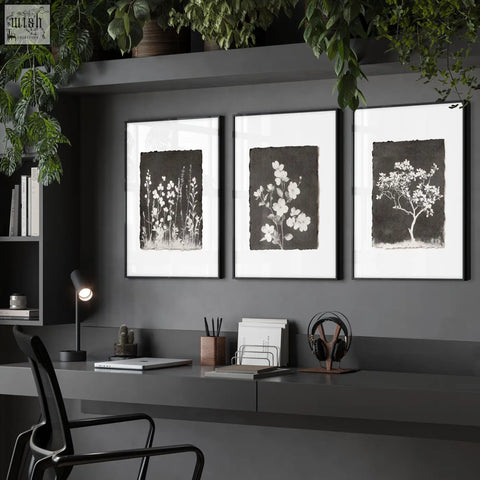 Three framed black and white botanical wall art prints with delicate floral designs on dark brown textured backgrounds