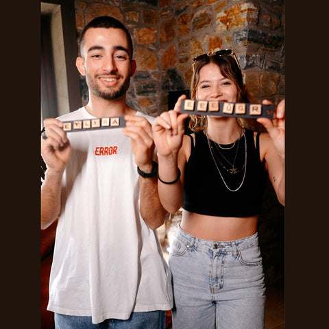 Black wooden scrabble tile holder with white letter tiles spelling lelira for the player forming words in dark scrabble wall game