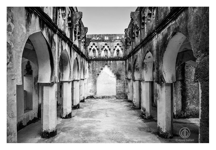 Black-and-white fine art photo by david ballam showing ancient stone arcade with arched columns and weathered walls