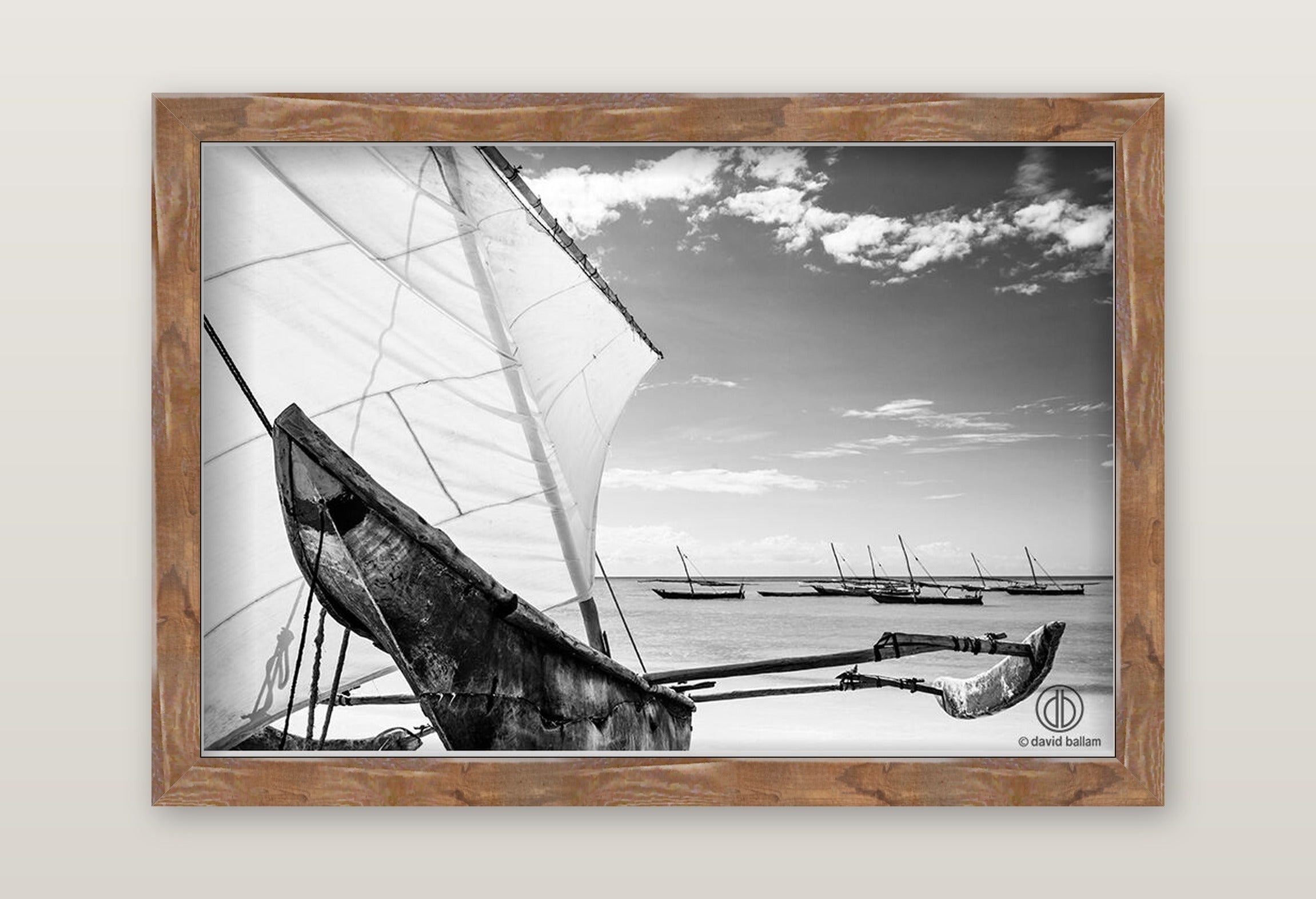Rustic wooden-framed fine art black and white photo by david ballam showing a traditional sailboat with white sails