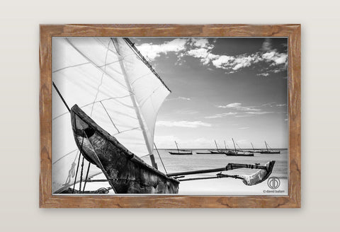 Rustic wooden-framed fine art black and white photo by david ballam showing a traditional sailboat with white sails