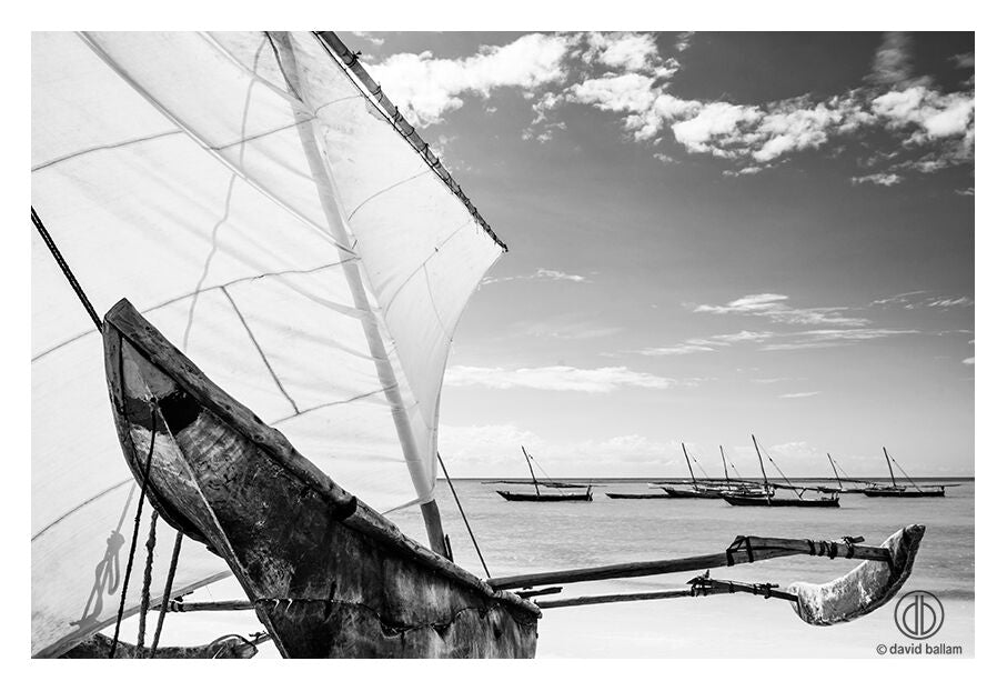 Weathered wooden boat with tall taut sail captured in fine art photo by david ballam titled zan_77