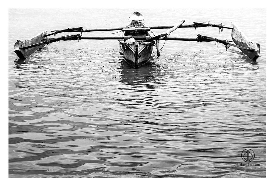 A traditional wooden outrigger canoe with natural wood grain by david ballam fine art titled ZAN_78