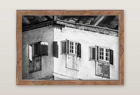Black and white fine art photo by david ballam featuring a weathered building with three wooden shuttered windows