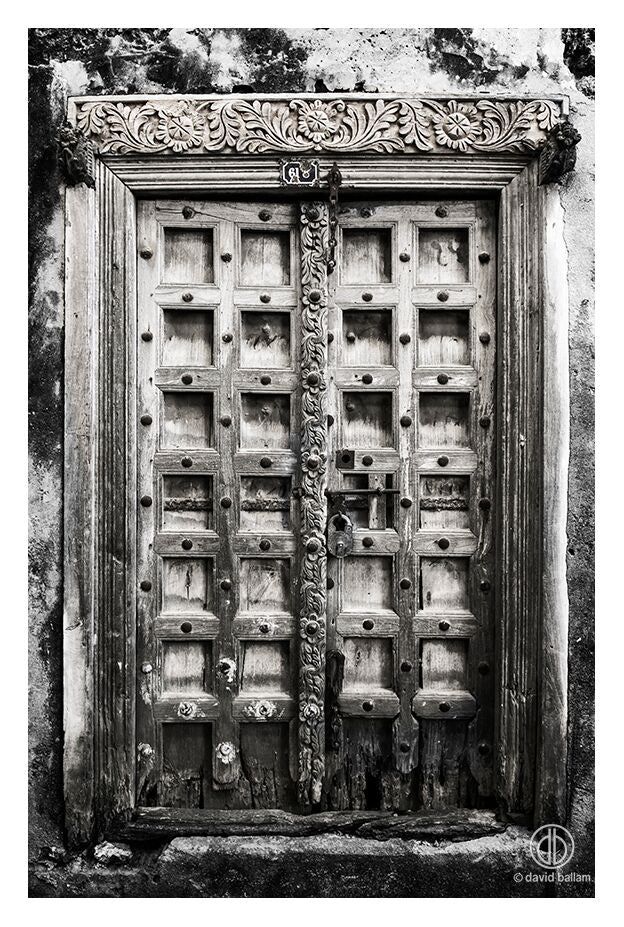 Carved wooden door with intricate floral and geometric patterns and metal studs in fine art by david ballam
