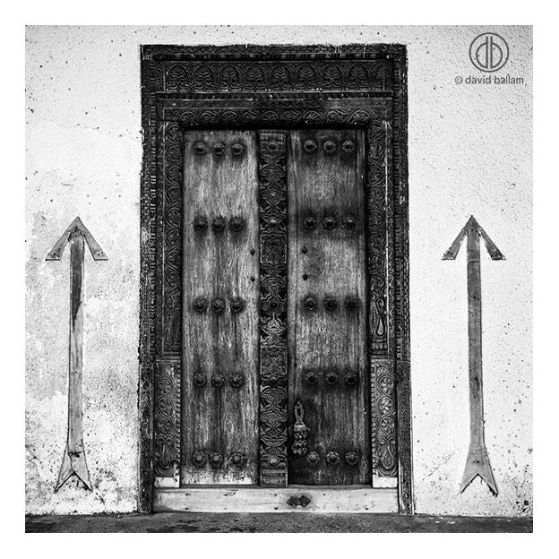 Ornate wooden double door with intricate carvings and dark metal studs by david ballam fine art design