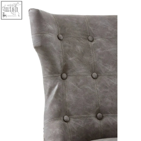 Daxton grey leather dining chair with gray tufted leather pillow and subtle button details on black rubberwood legs