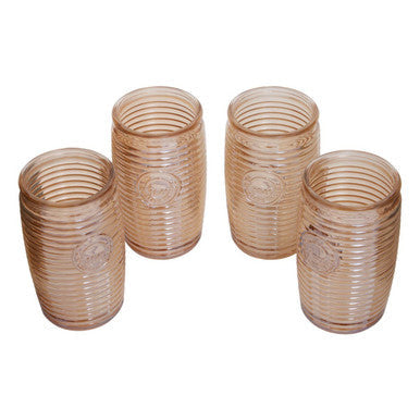 Four gold ribbed glass tumblers in translucent amber with vertical ridges and embossed circular designs