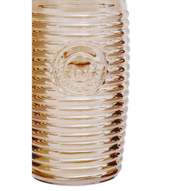A translucent amber glass vase with vertical ridges and an embossed logo paired with four gold ribbed glass tumblers