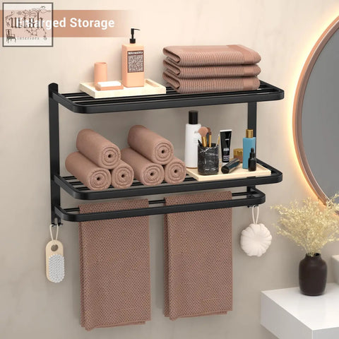Black stainless steel wall-mounted towel rack with two-tier towel shelf holding beige towels and toiletries