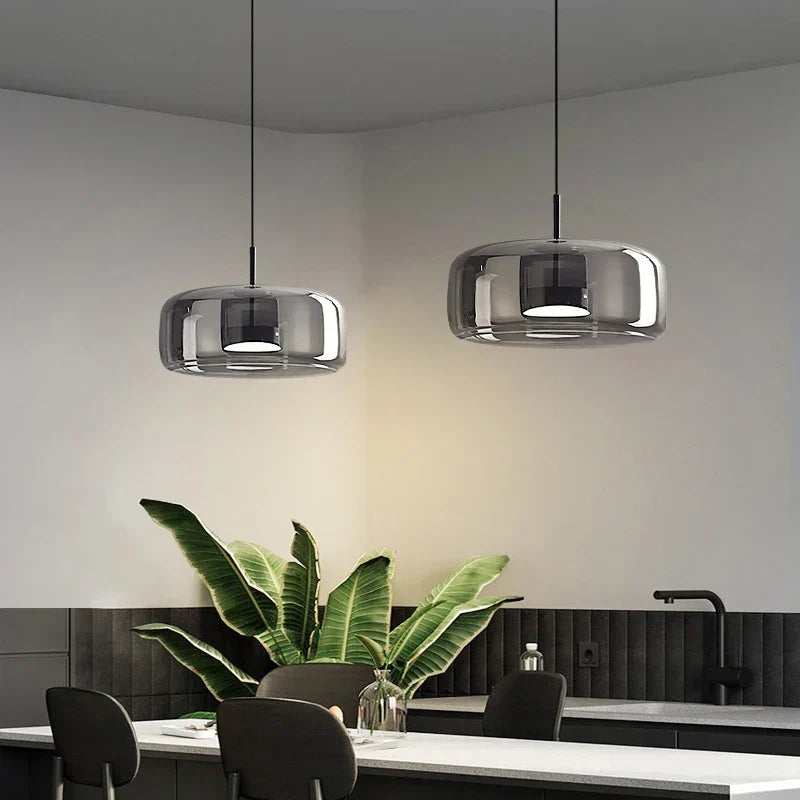 Two decao light pendant lights with reflective chrome finish and rounded bowl shapes hang above kitchen island