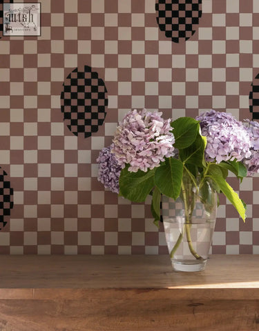 A clear glass vase with light purple hydrangeas in front of deco checkers wallpaper in toasted coco by micaela sharp digital printing